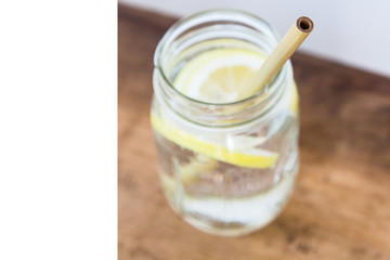 Lemon water and bamboo drinking straw.