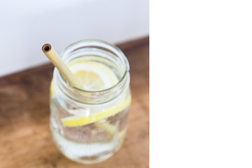 Lemon water and bamboo drinking straw.