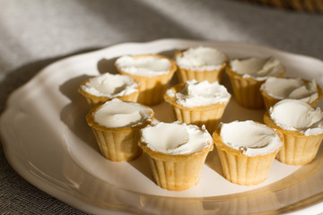 Tartlets with custard or cottage cheese. Empty tartlets or pie on a white table. Food lay flat. The view from the top. The concept of preparing food for the holiday table.