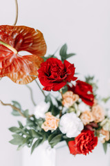 Decor of a stylish wedding ceremony. The decoration of the arch with red roses and wedding floristry. Modern trends in wedding bouquets.