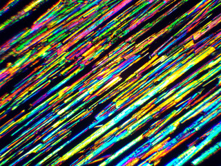 Crystal layer on microscope object glass, seen in polarized light. This causes random unforeseeable color effects.