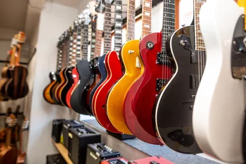 Aluminium Prints Music store Close up of electric guitars in a row in huge instrument shop, music instrumental concept