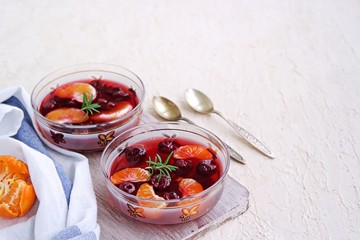 Dessert, sweet fruit jelly with cherries and tangerines in portioned bowls on a gray concrete background. Lenten desserts. Desserts without baking. Copyspace.