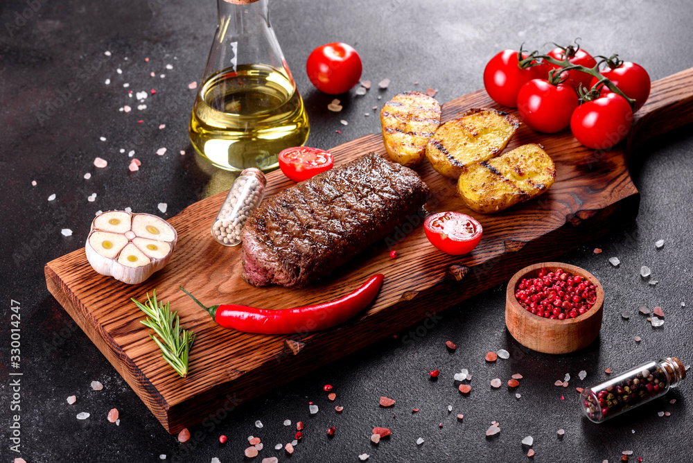 Wall mural Ribeye steak with potatoes, onions and cherry tomatoes