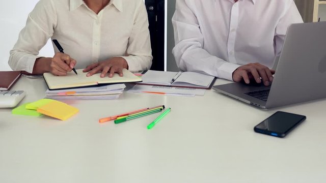 4k video of Teaching helping technology concept. Woman young teacher or tutor with adult students in classroom at desk with papers, laptop computer. Studies course.