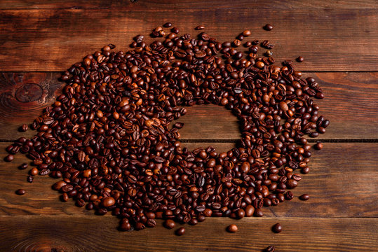 Grains of fresh roasted coffee close-up against a dark background © chernikovatv