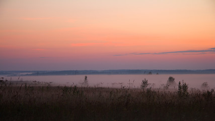 Landscape with a lilac fog at sunset in dark tones