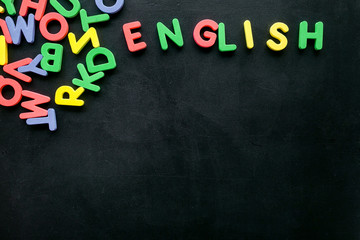 Obraz premium English text near letters on black background top-down copy space