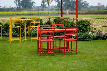 View of Garden resort having colourful table & chair placed for having food in Delhi India, Resort...