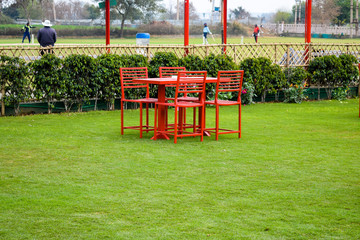 View of Garden resort having colourful table & chair placed for having food in Delhi India, Resort...