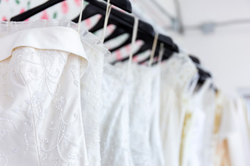 There are a variety of bridal dresses that hang on the clothesline.