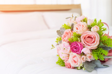 Very beautiful bouquet of flowers laid on a clean white bed.