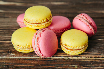 Sweet colorful French macaroon cookies dessert on brown wooden table over white wooden background