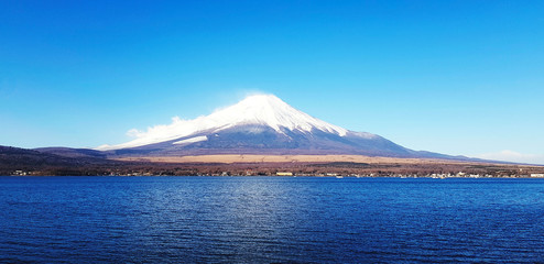 Beautiful landscape view of Fuji mountain with lake and clear blue sky background. Landmark for travel in Japan and Asia. Beauty in nature and Natural wallpaper