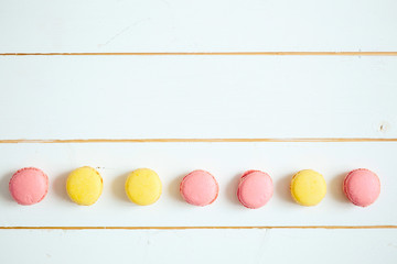 Sweet colorful French macaroon cookies dessert on white wooden table