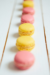 Sweet colorful French macaroon cookies dessert on white wooden table