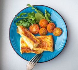 Plate with omelet and fresh vegetables on a white plate
