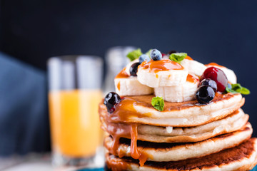 Delicious and lush pancakes with fresh fruits and berries, poured with salted caramel.