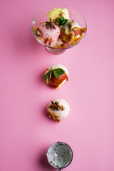 Colorful delicious ice cream on a pink background, with spices, mint leaves.