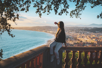 young female watching sunset in Nice, France. beautiful panoramic aerial cityscape top view of Nice, of French riviera. Landscape of harbor, town of Cote d'Azur France. woman enjoying evening