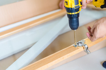 Man with drilling and making wardrobe or closet at home.Building master with drilling...