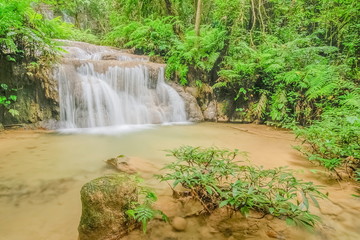 Fototapeta na wymiar view of silky waterfall flowing around with green forest background, Pu Kaeng Waterfall, Doi Luang National Park, Chiang Rai, Northern of Thailand.