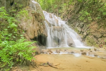 view of silky waterfall flowing around with green forest background, Pu Kaeng Waterfall, Doi Luang National Park, Chiang Rai, Northern of Thailand.