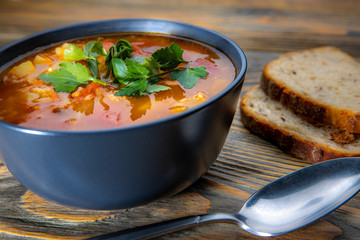 Kharcho soup with meat and rice on a wooden table, closeup, shallow depth of field. Concept, healthy food.