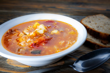 Kharcho soup with meat and rice on a wooden table, closeup, shallow depth of field. Concept, healthy food.