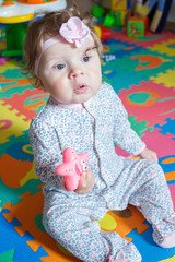 Playing little child on the colored mat for developing, soft focus background