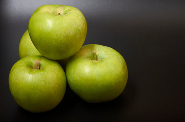 Three fresh green apples isolated on black background