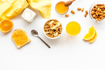 Homemade granola for morning meal. White desk with taost and fruits top-down frame copy space