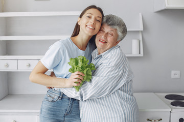Old woman in a kitchen. Grandparents at home. Woman in a whire shirt