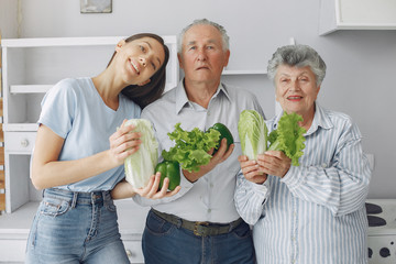 Family in a kitchen. Grandparents with granddaughter. Family made a salad