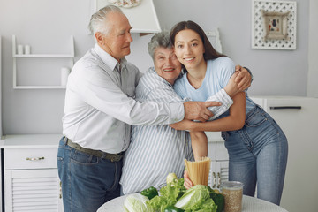 Family in a kitchen. Grandparents with granddaughter. Family made a salad