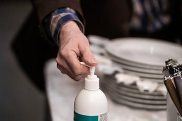 Hand using disinfection pump in a restaurant