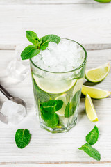 Mojito drink in a glass glass with ice and lime slices