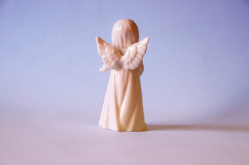 White porcelain angel figure on a plain background