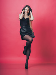 Brunette sexy girl posing at the pink background