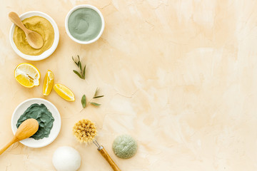 Natural spa concept with various cosmetic clays. Composition with healing herbs, wooden massage brush on brown table, flat lay, space for text