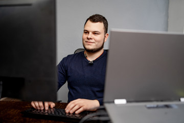 Male programmer working on desktop computer near monitor at office in software development company. Website design programming and coding technologies.