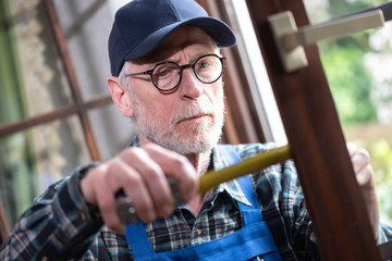Repairman taking measures with tape measure