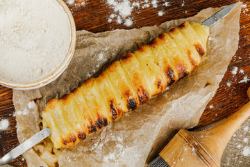homemade trdelnik with kitchenware on wooden tray
