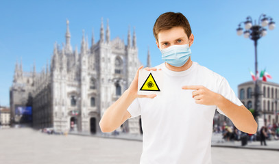 health, safety and pandemic concept - man wearing protective medical mask holding coronavirus...