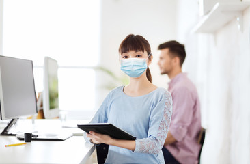 Obraz premium health, safety and pandemic concept - asian young woman wearing protective medical mask for protection from virus disease at office