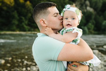 Dad kissing daughter outdoors. The concept of summer holiday. Father's, baby's day. Spending time together. Family look. Sun light.