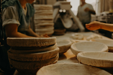 Making dough by female hands on wooden table background