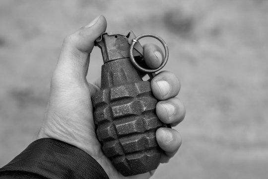 black and white photo of a military grenade in hand