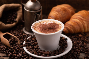 Cup of cappuccino and coffee beans