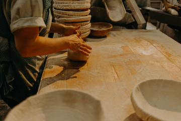 female hands in flour closeup kneading dough on table
